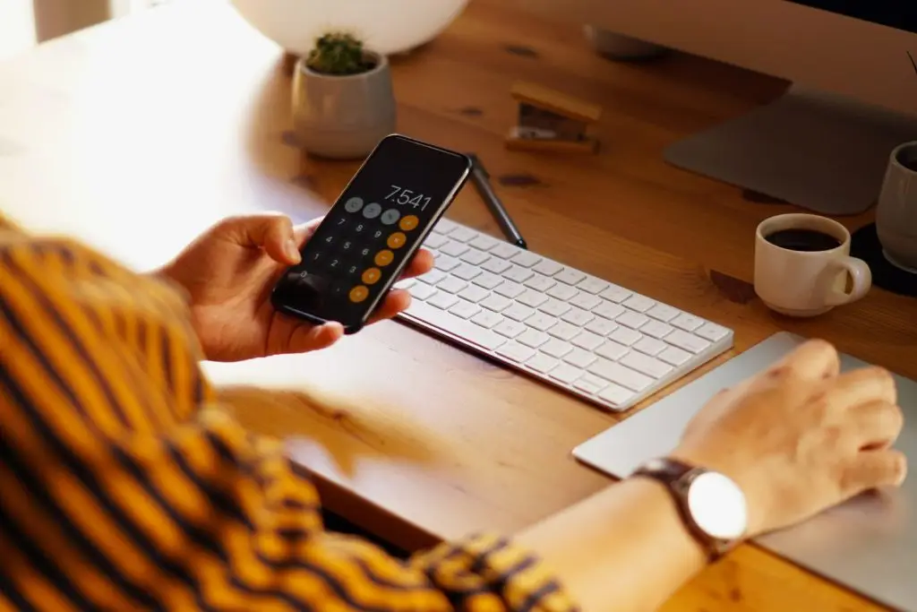 Homem usando celular em mesa de trabalho